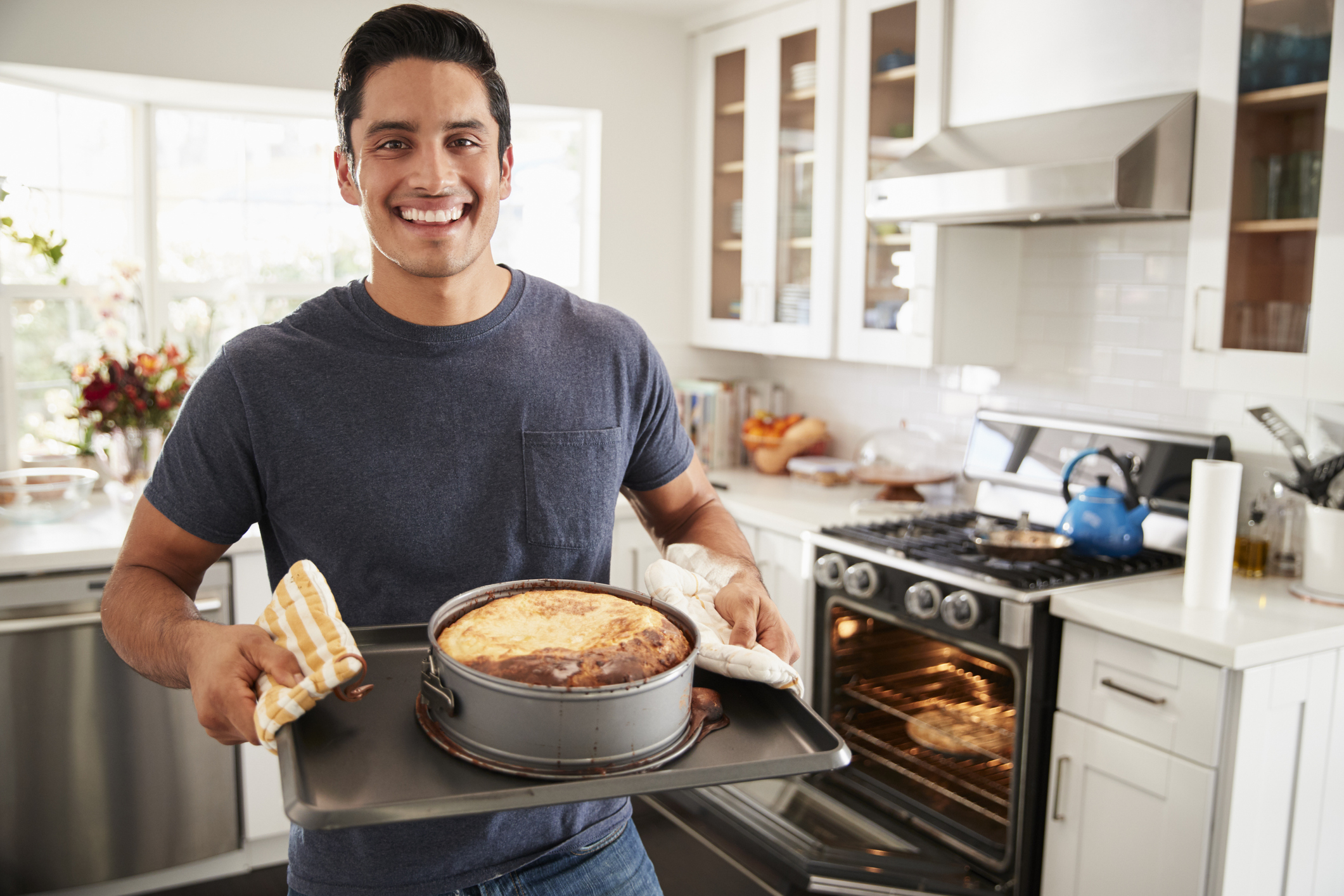 man in the kitchen showing off something he just baked
