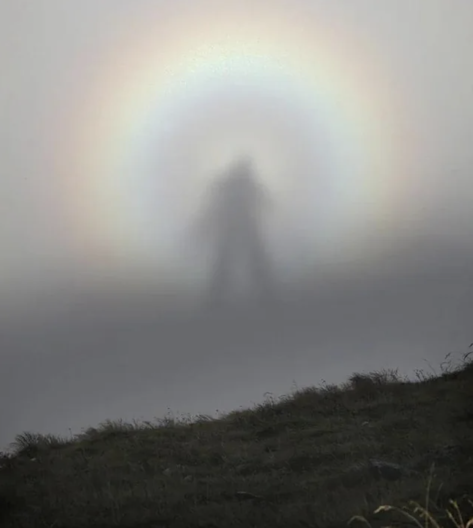 a silhouette of a person in a rainbow