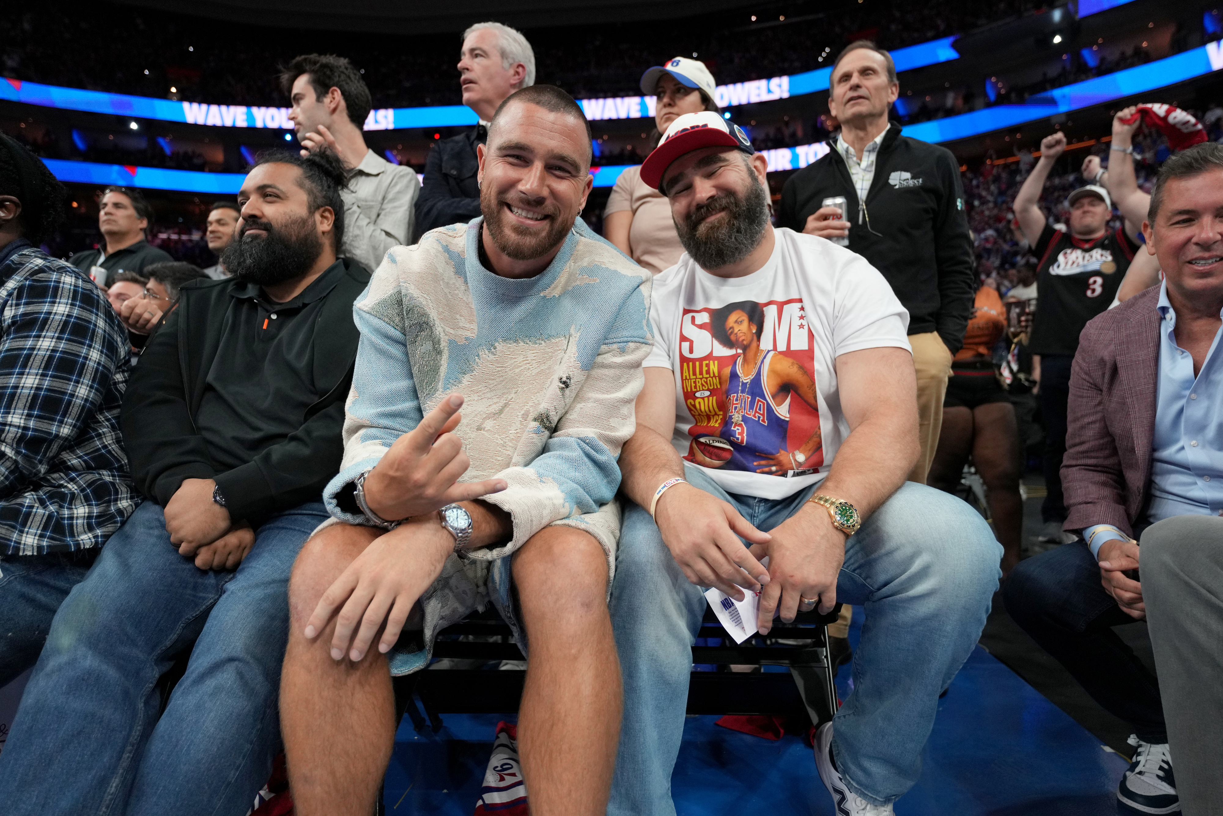 Travis and Jason smiling and sitting together in an audience