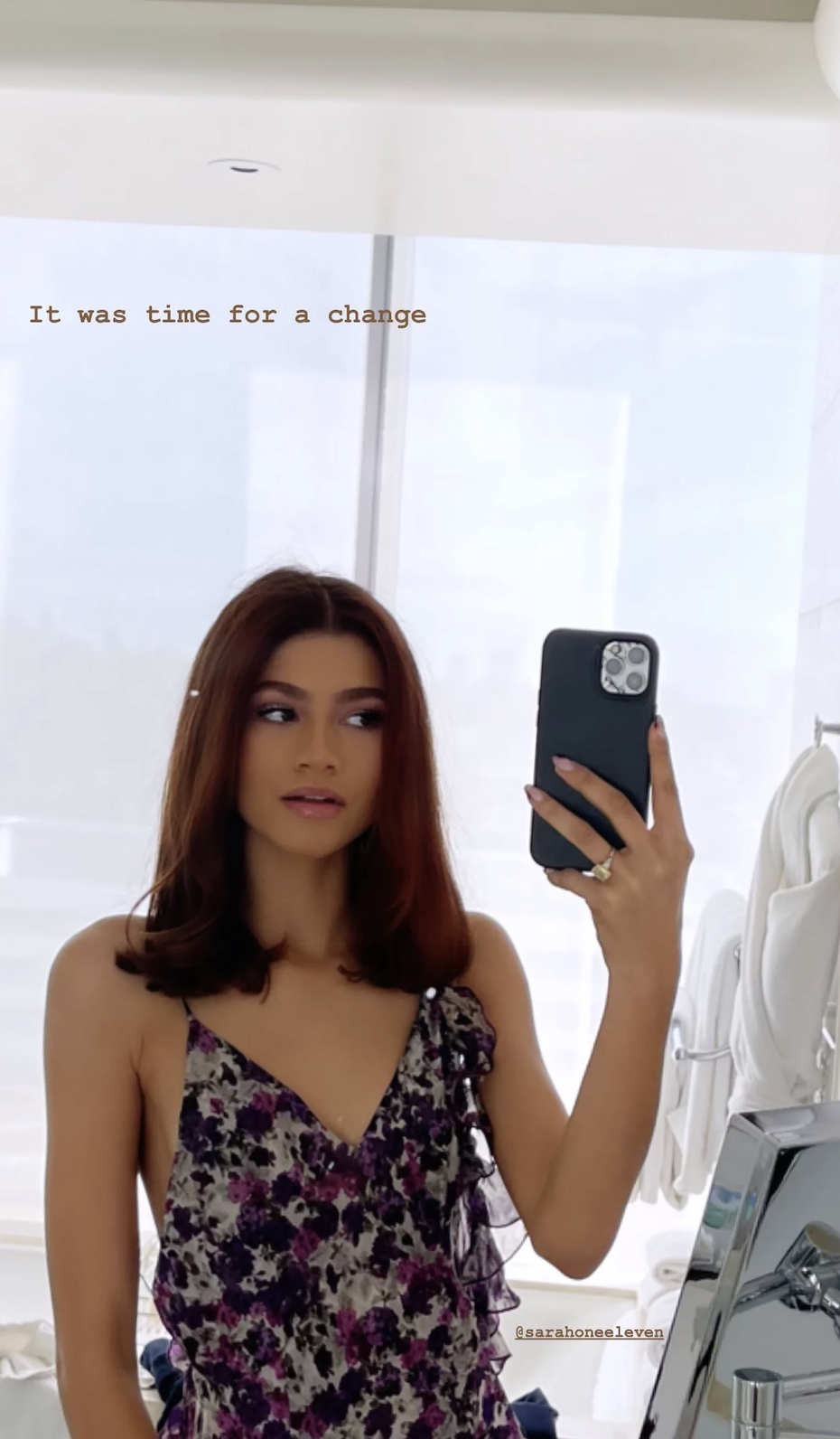 A mirror selfie of Zendaya with shorter red hair and wearing a ring while holding her phone