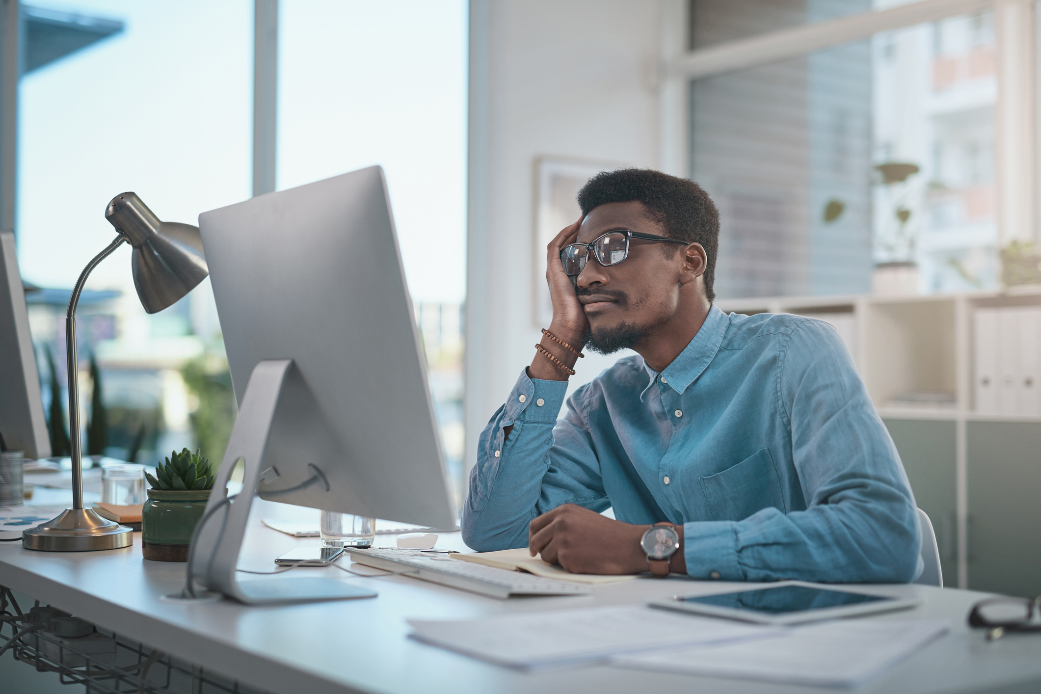 man sitting at his desk staring at the computer screen