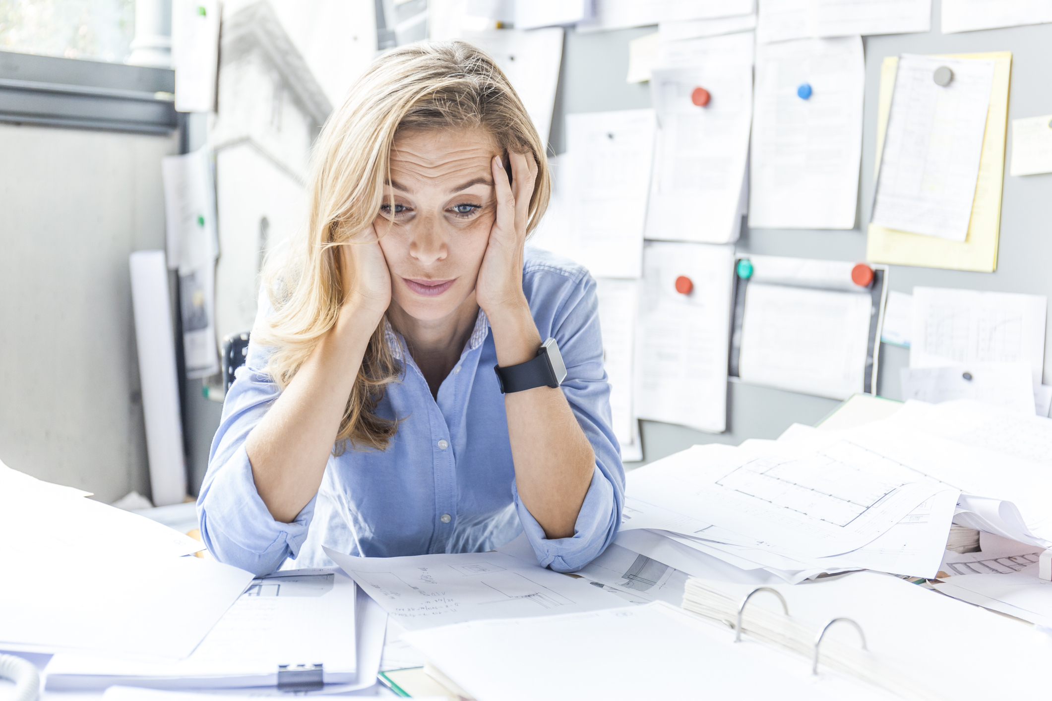 frustrated person at their desk of scattered papers