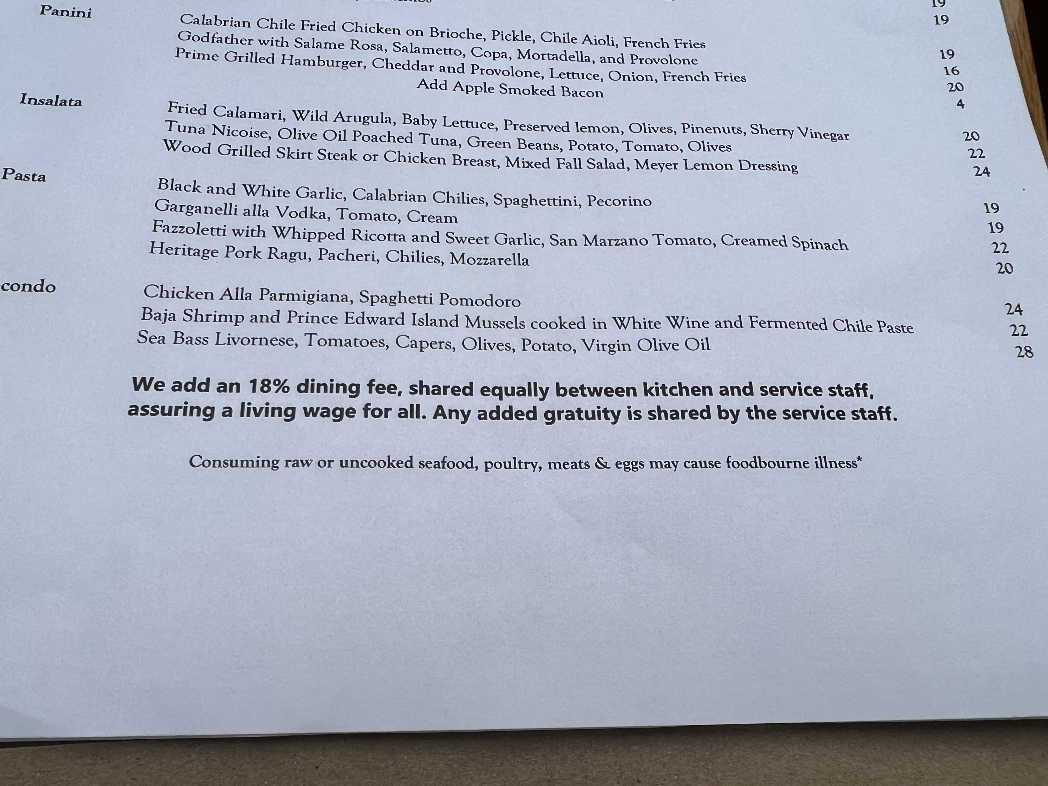 The bottom of a menu says &quot;we add an 18% dining fee, shared equally between kitchen and service staff. Any added gratuity is shared by the service staff&quot;