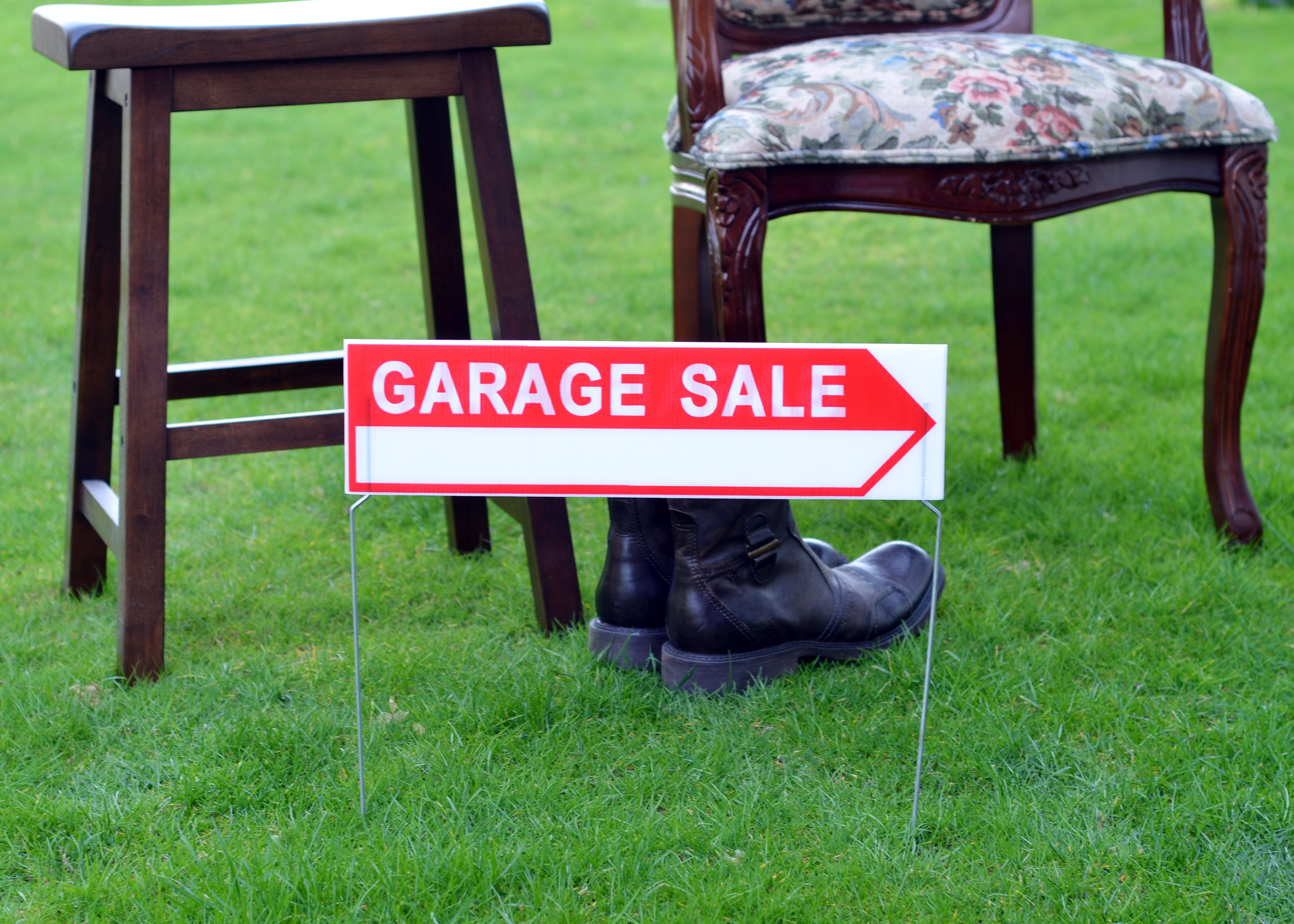 a garage sale sign in front of a few pieces of furniture