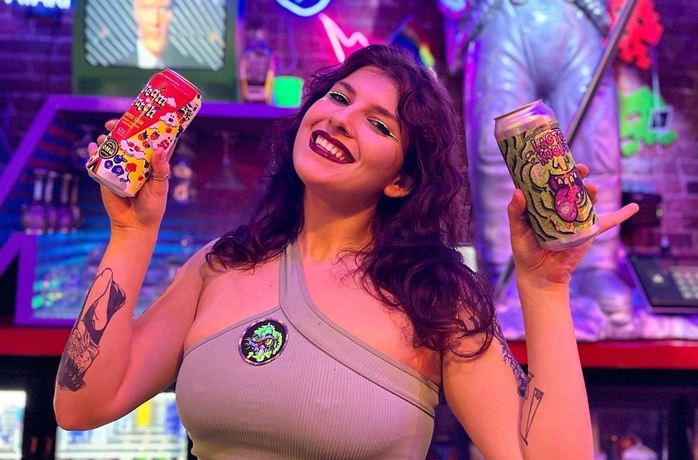 Woman holds up beer games in retro bar