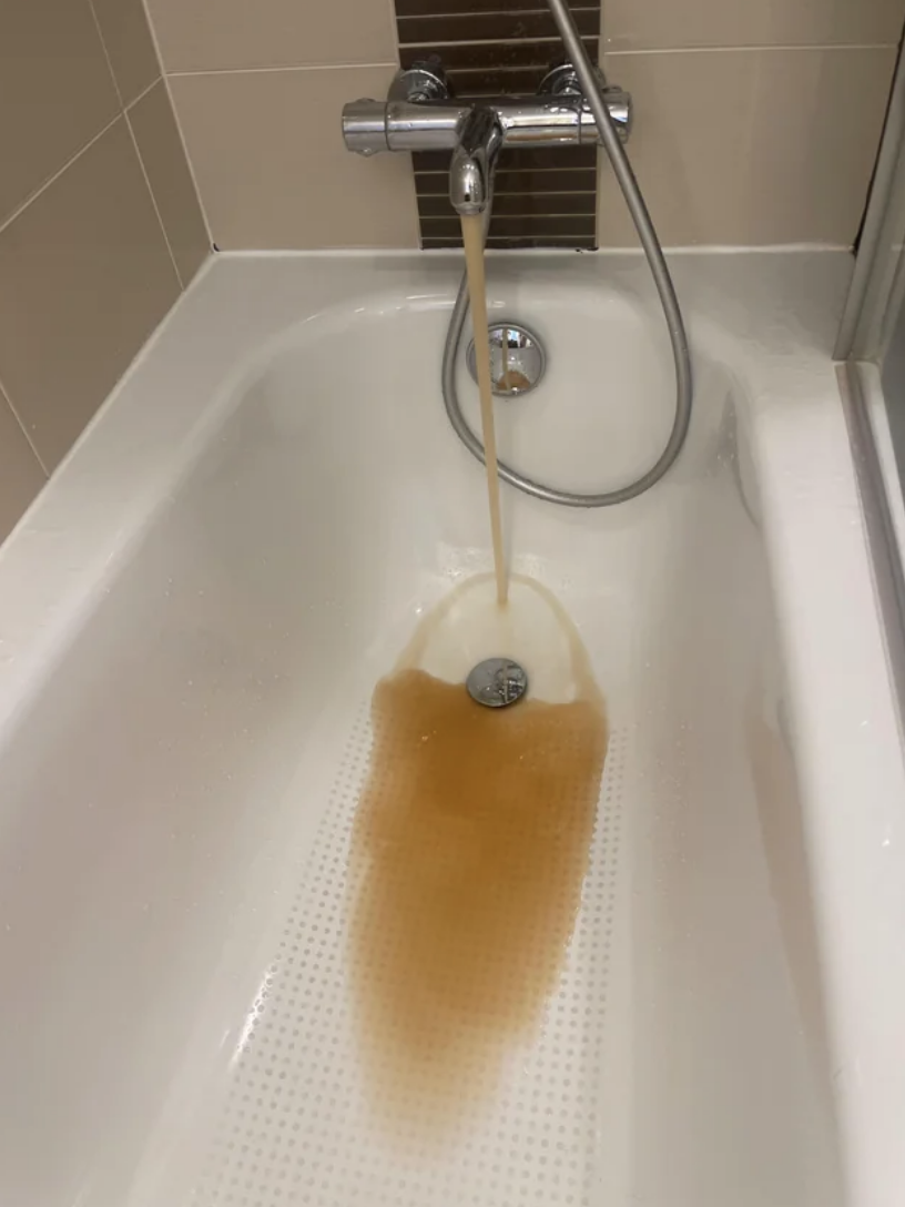 Dirty water coming from the faucet of a bathtub