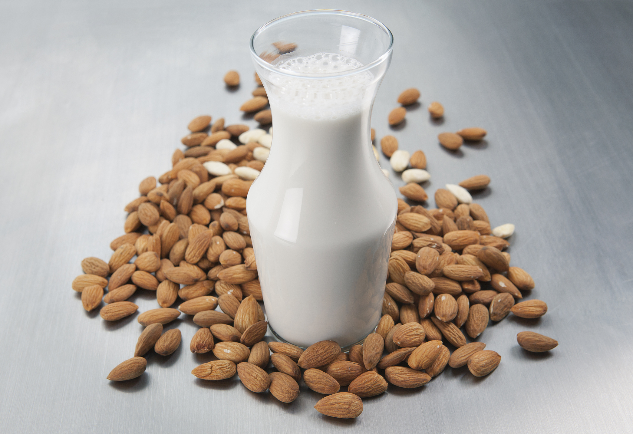 Almonds surrounding a cup of milk