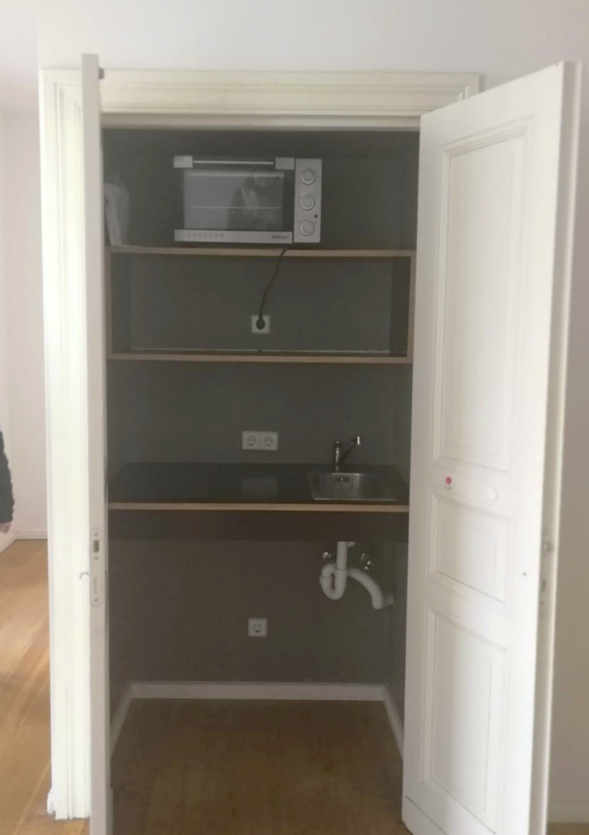 a sink and shelves are in the closet