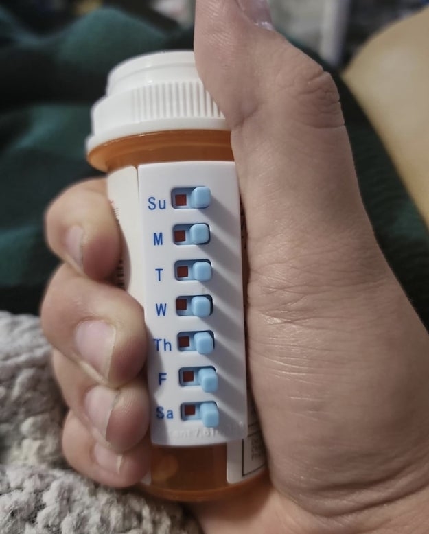 the take-n-slide adhered to the side of a pill bottle