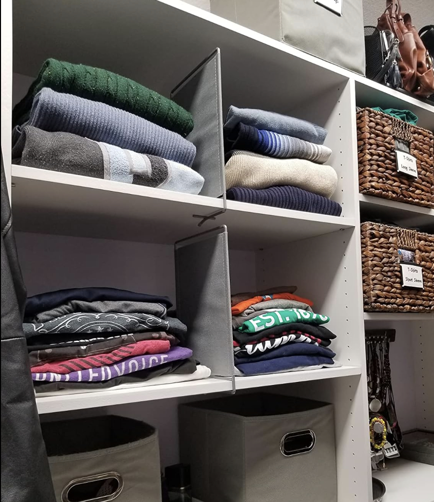 shelf dividers in a closet separating stacks of shirts and sweaters