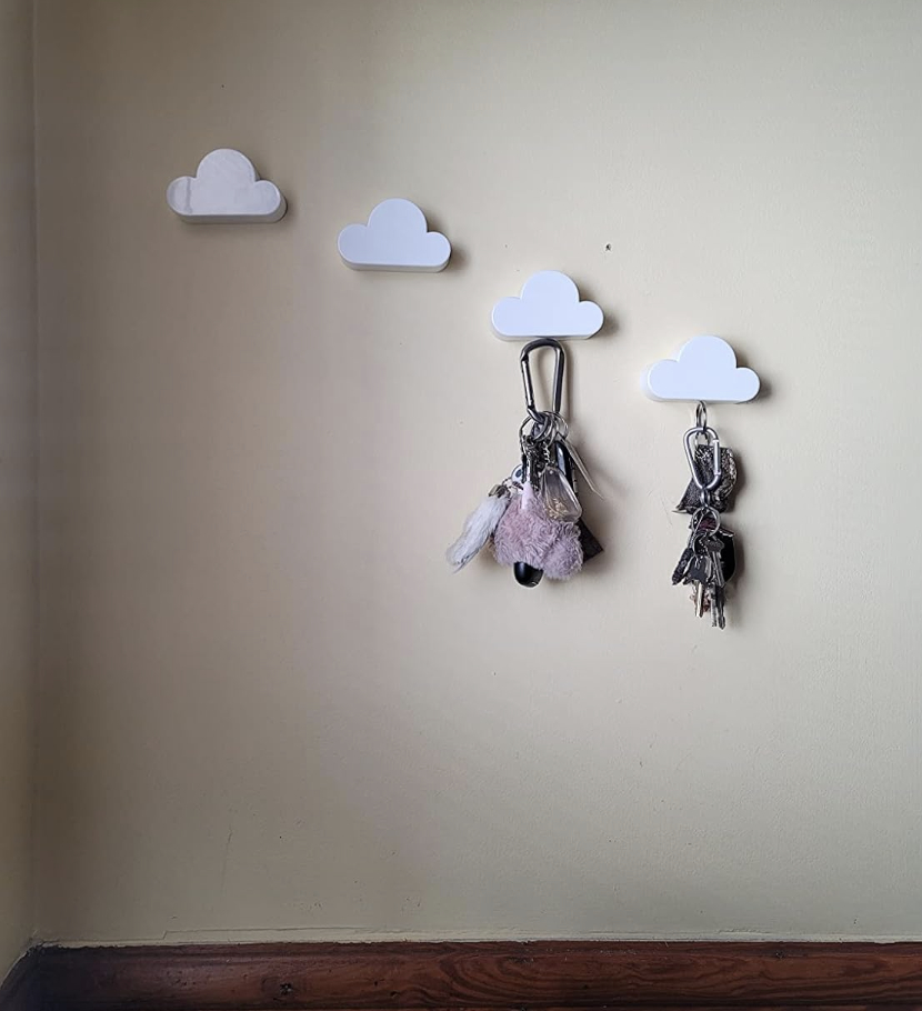 four wall cloud key holders on a wall holding keys
