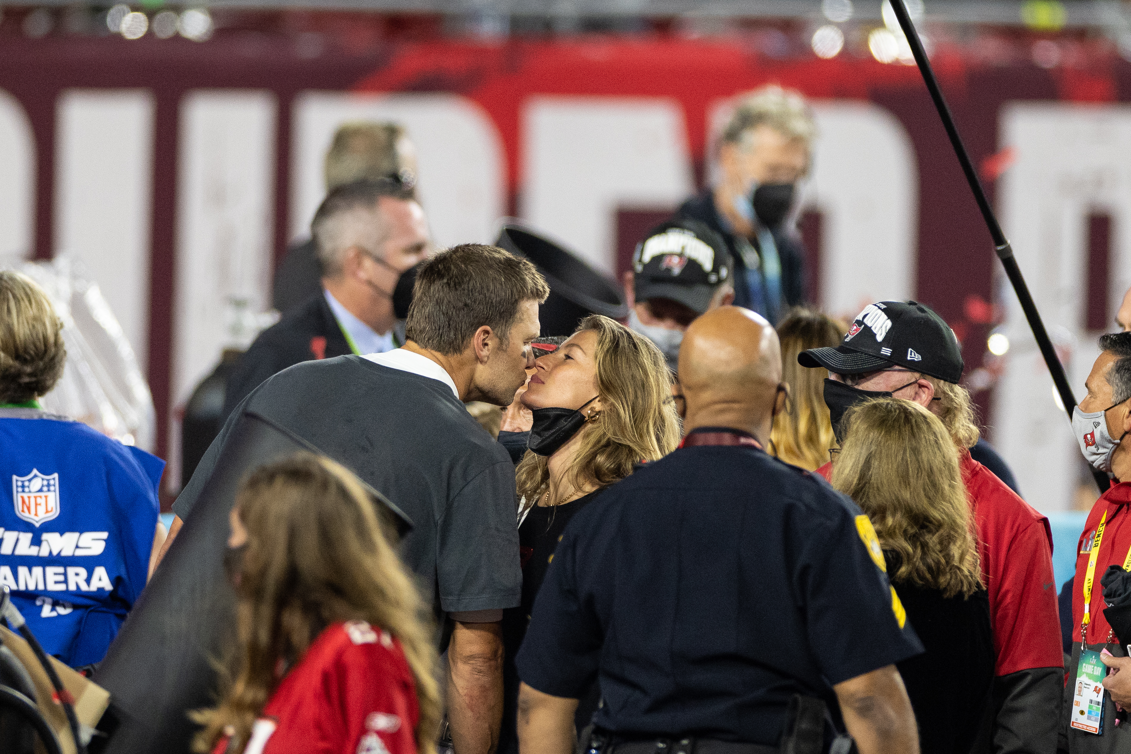 Tom and Gisele kissing on the football field after a game
