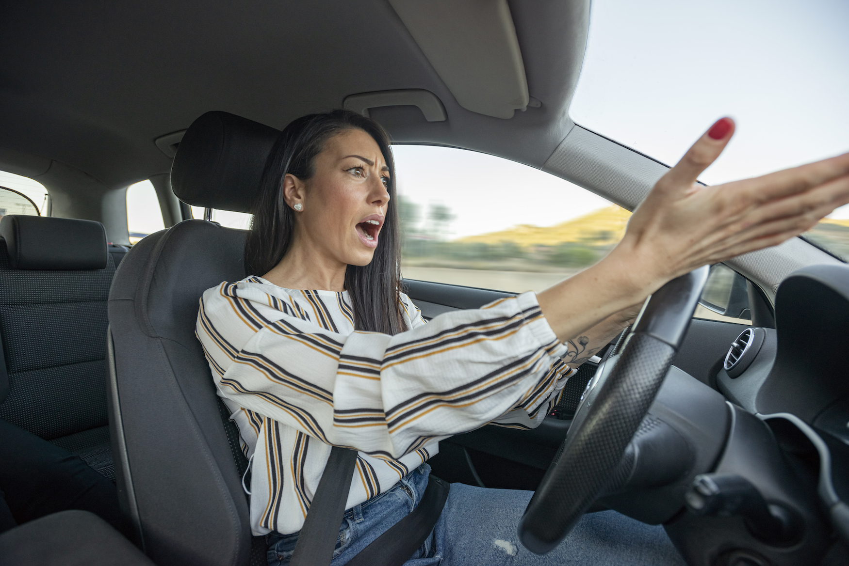 A woman outraged while behind the wheel of her car