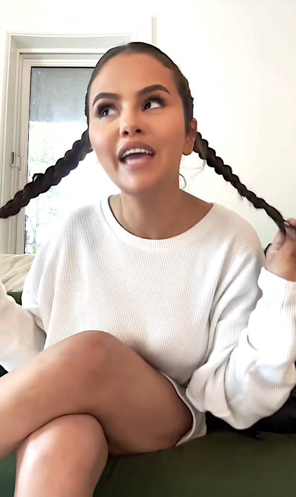 Closeup of Selena Gomez playing with her braided pigtails