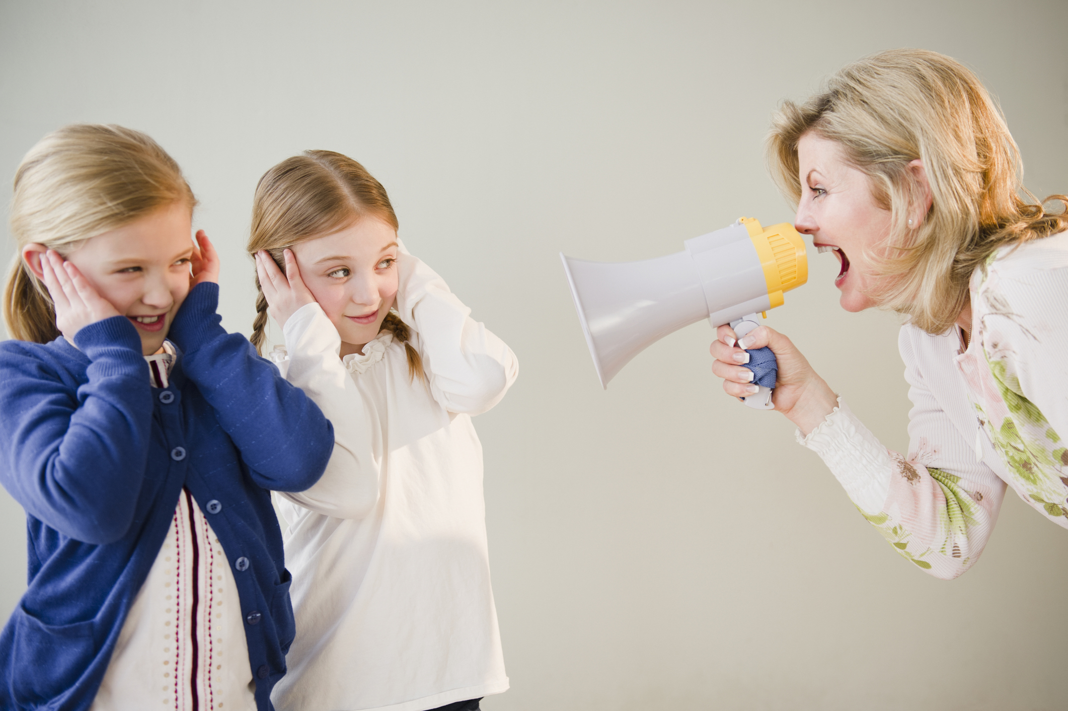 A woman yelling at her daughters with a megaphone