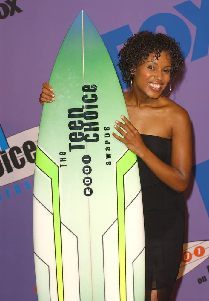 Kerry Washington in her 20s smiling at the 2001 Teen Choice Awards and holding a surfboard award