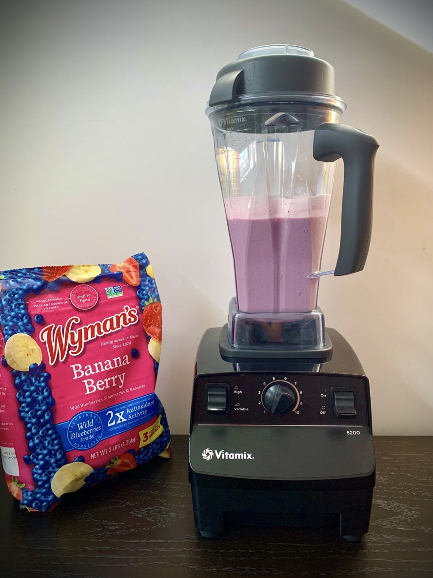 blender with bag of frozen fruits next to it