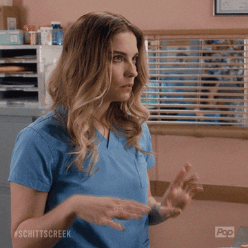 Alexis Rose says "SORRY" wearing scrubs.