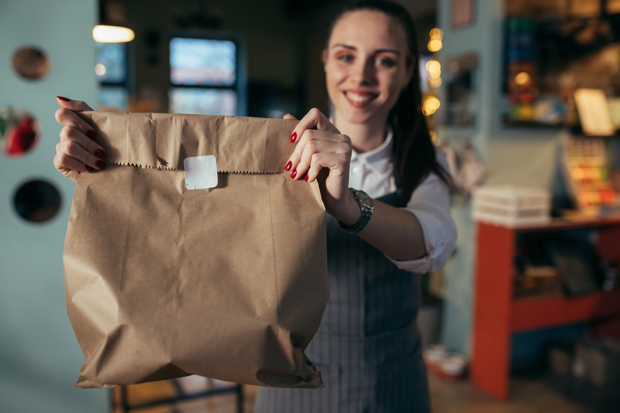 A woman holding up a brown bag