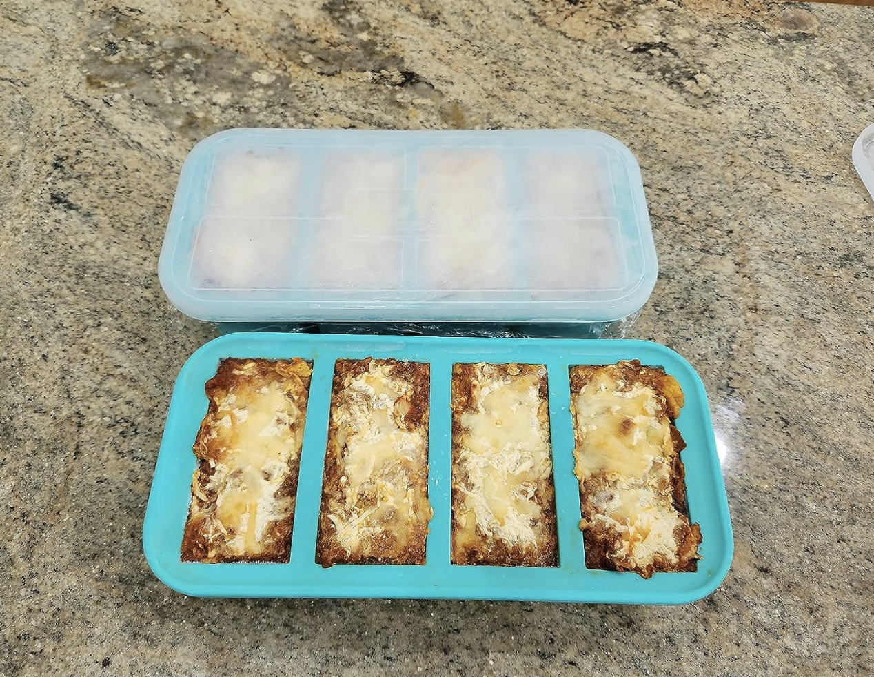 two trays filled with frozen lasagne and one with lid on