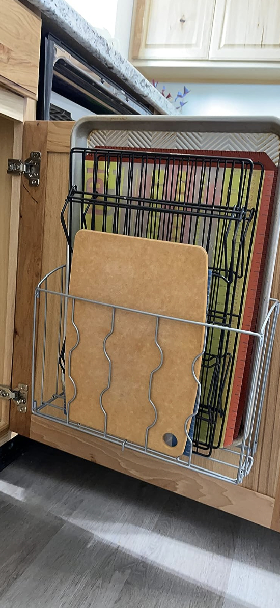 organizer attached to inside of cabinet filled with various kitchen boards