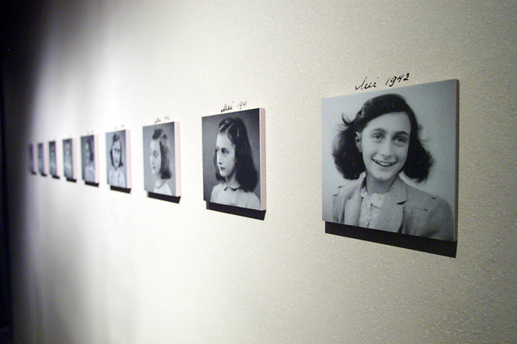 Various photos of Anne Frank handing in a gallery