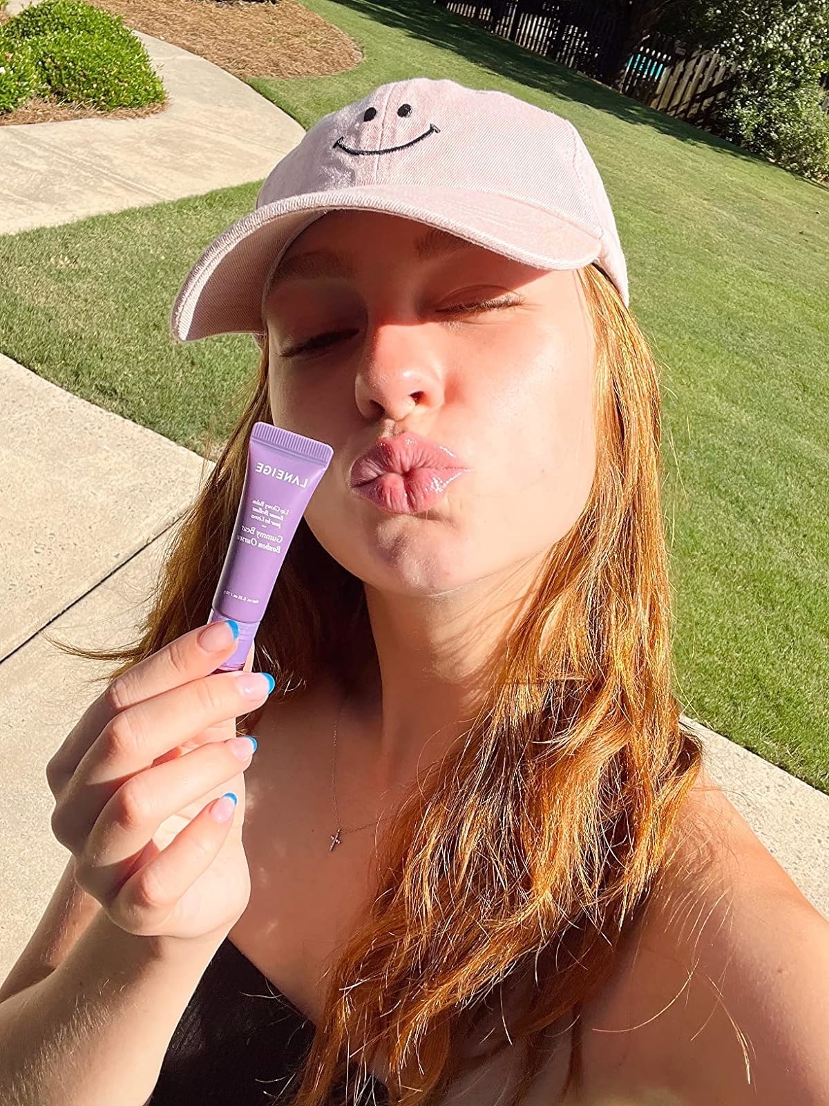 Reviewer wearing the lip balm and holding the tube of it