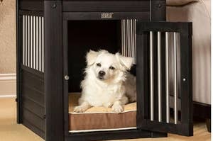 A dog inside of a black crate that looks like a side table
