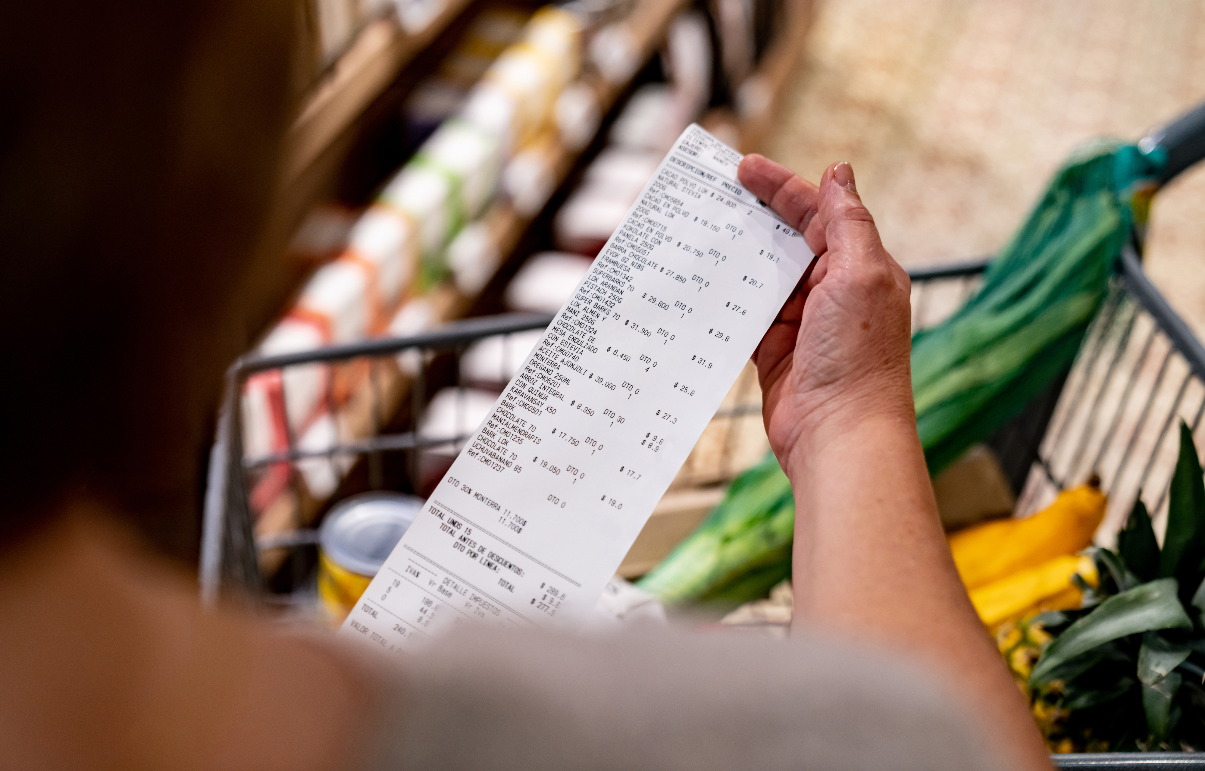 woman looking at grocery store receipt