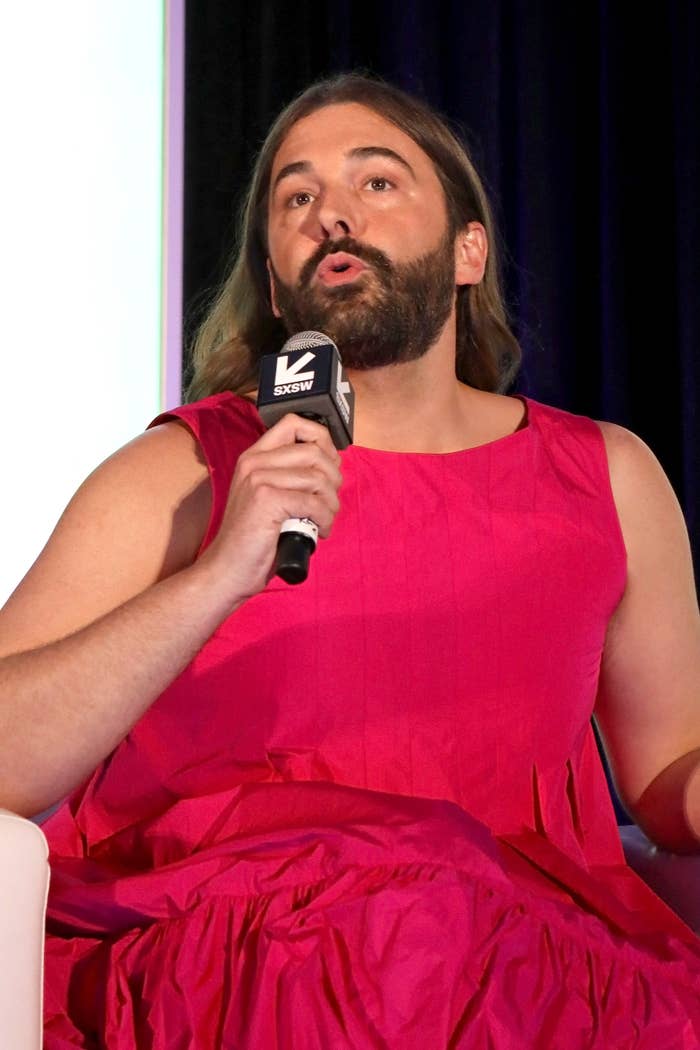 Jonathan sitting onstage speaking into a microphone