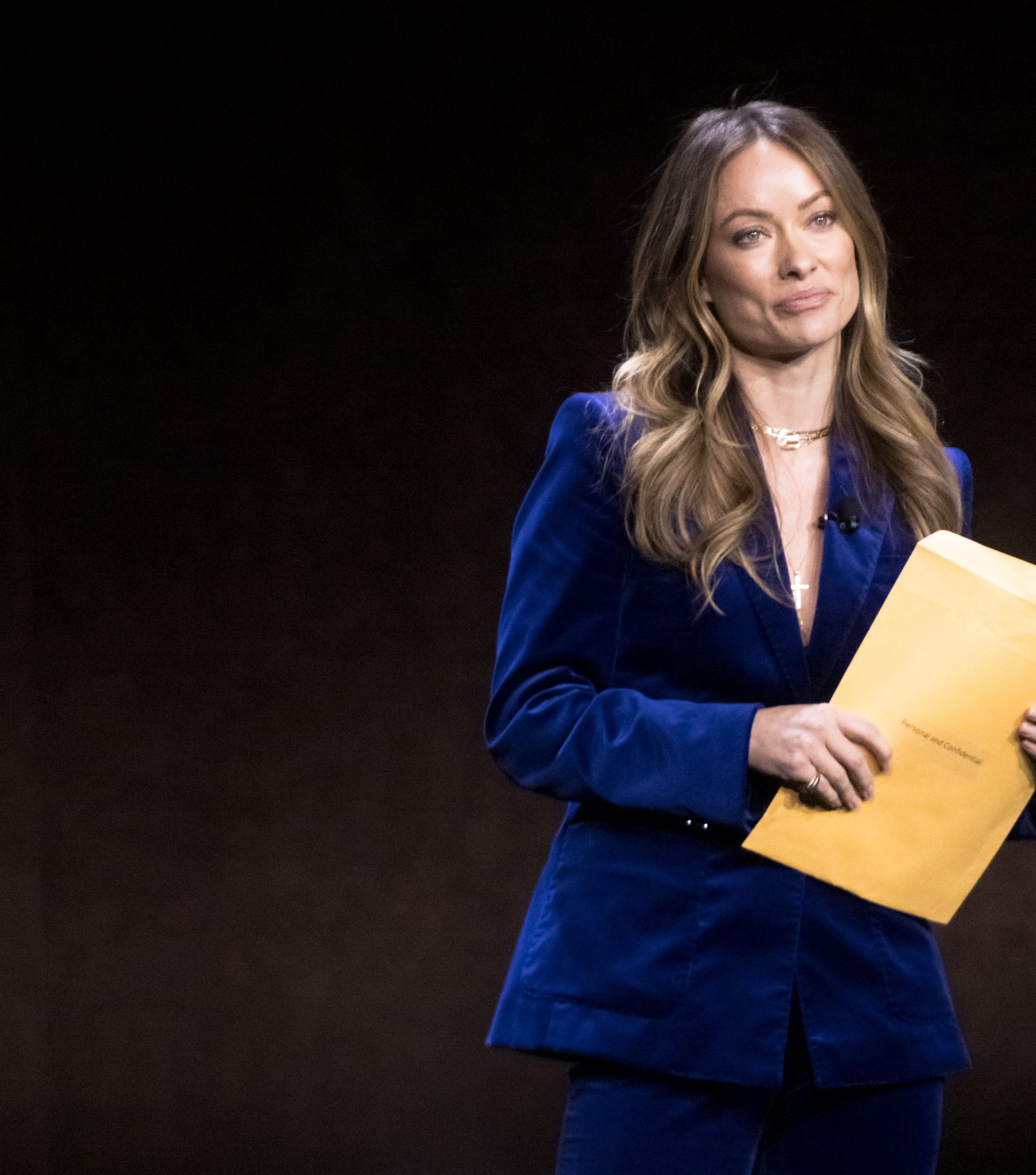 Olivia Wilde holding papers onstage