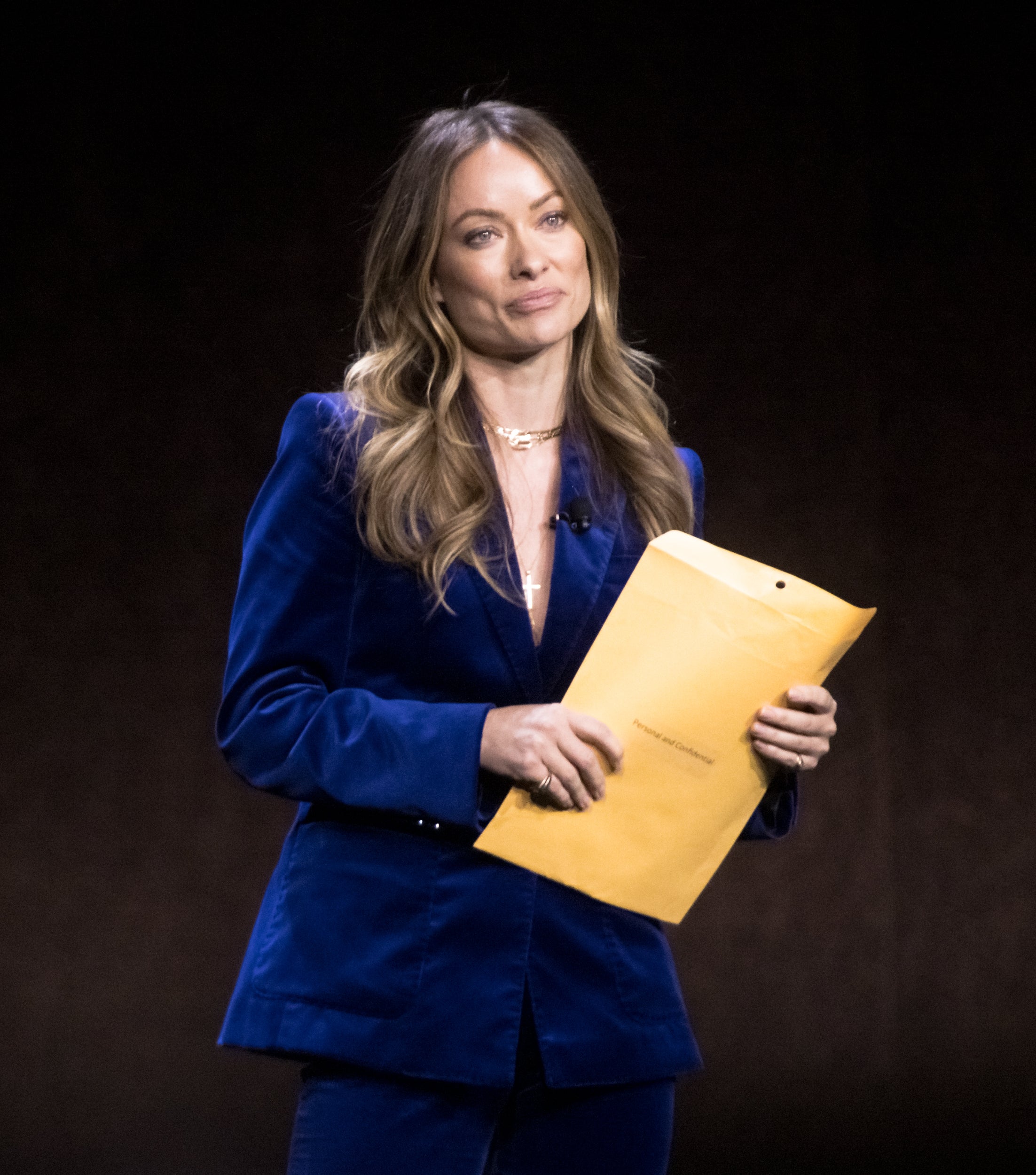 Olivia Wilde holding papers onstage