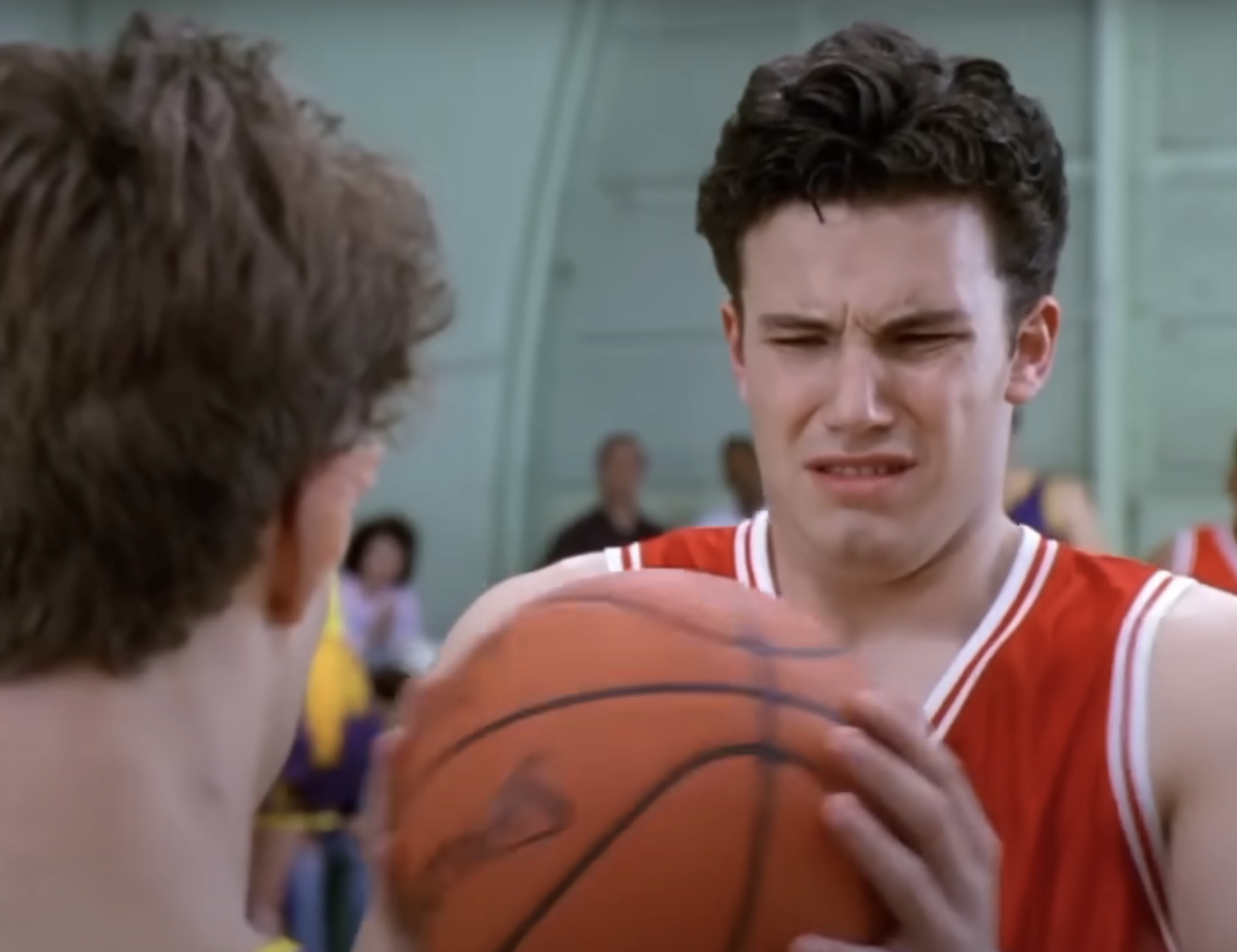 Ben holding a basketball and grimacing