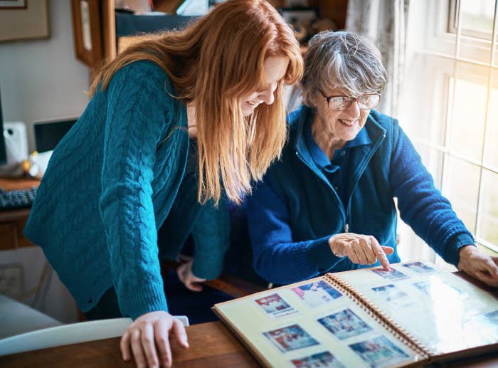 woman looking at family photos with her grandmother