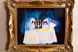 a gold framed art print of two cute ghosts having a candlelit dinner, like on a date