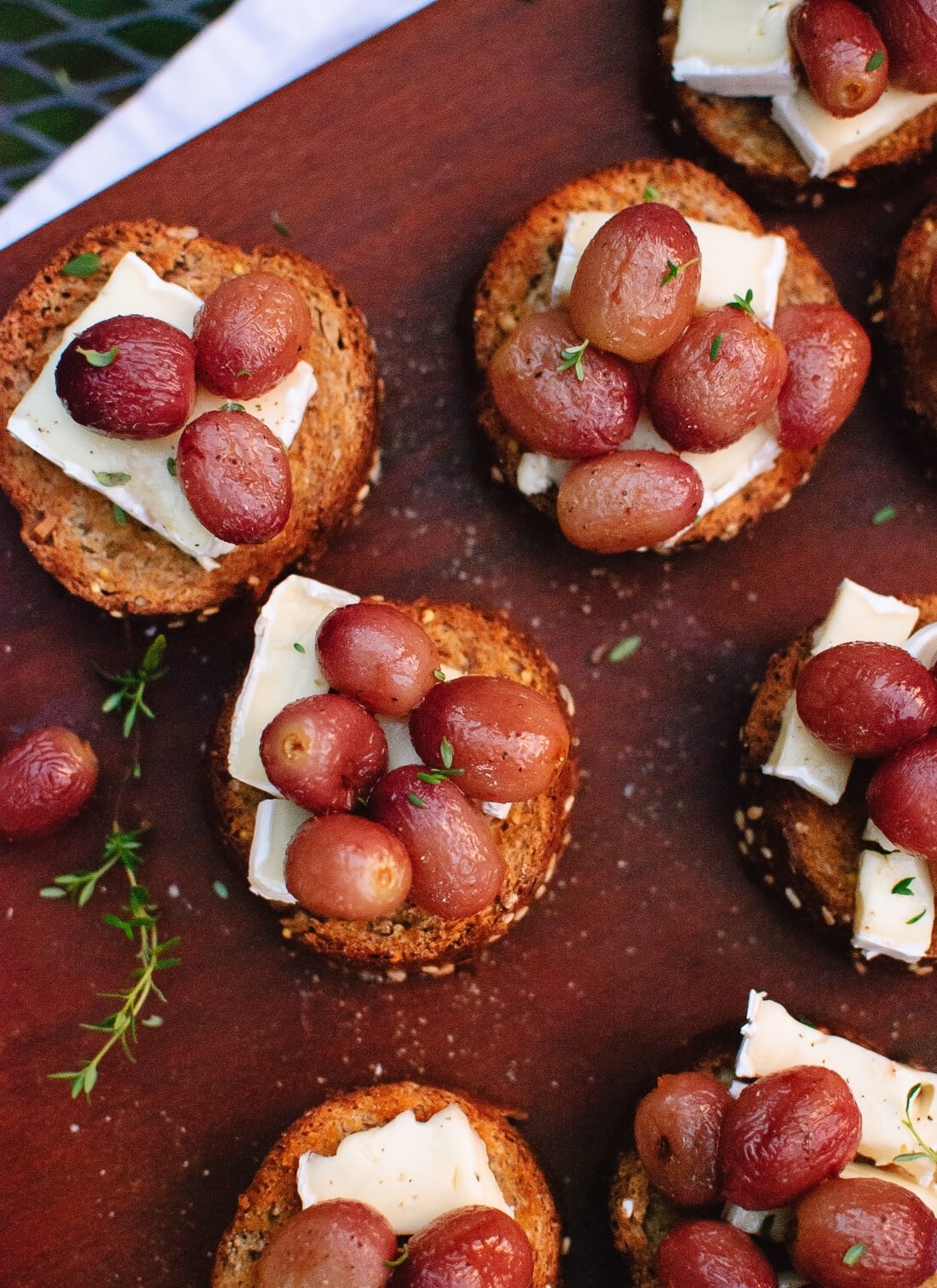 roasted grapes and brie on top of small pieces of toasted bread
