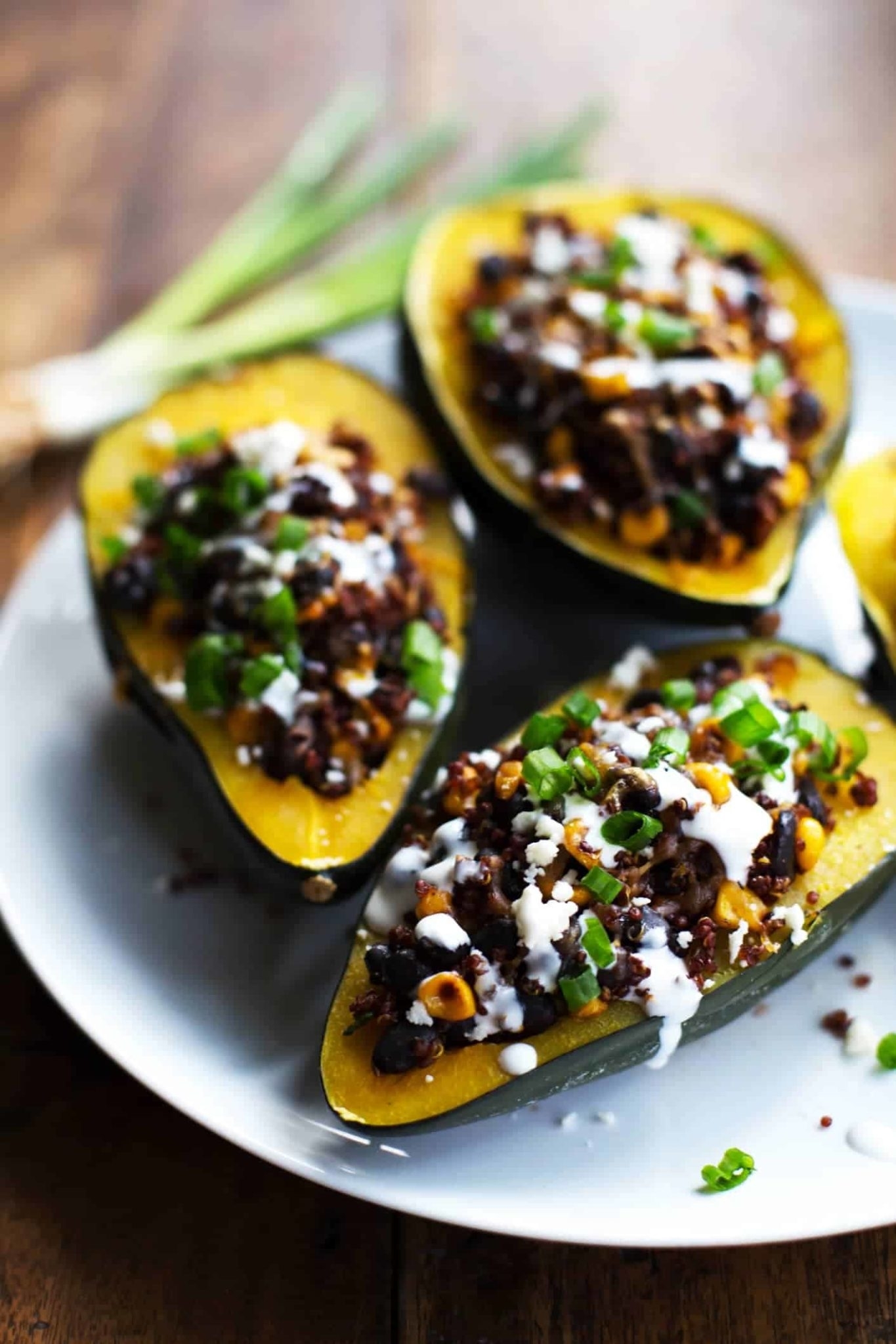 stuffed acorn squash on a plate drizzled with crema