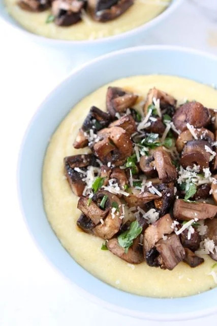 roasted mushrooms on top a bowl of polenta with parmesan cheese