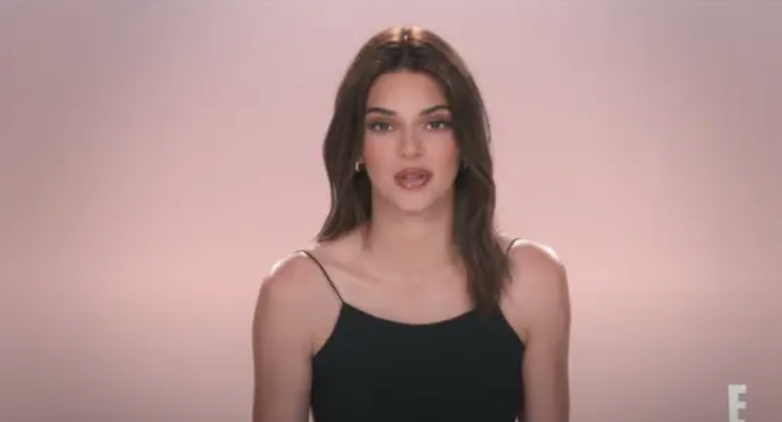 Close-up of Kendall in the confessional, wearing a spaghetti-strap top