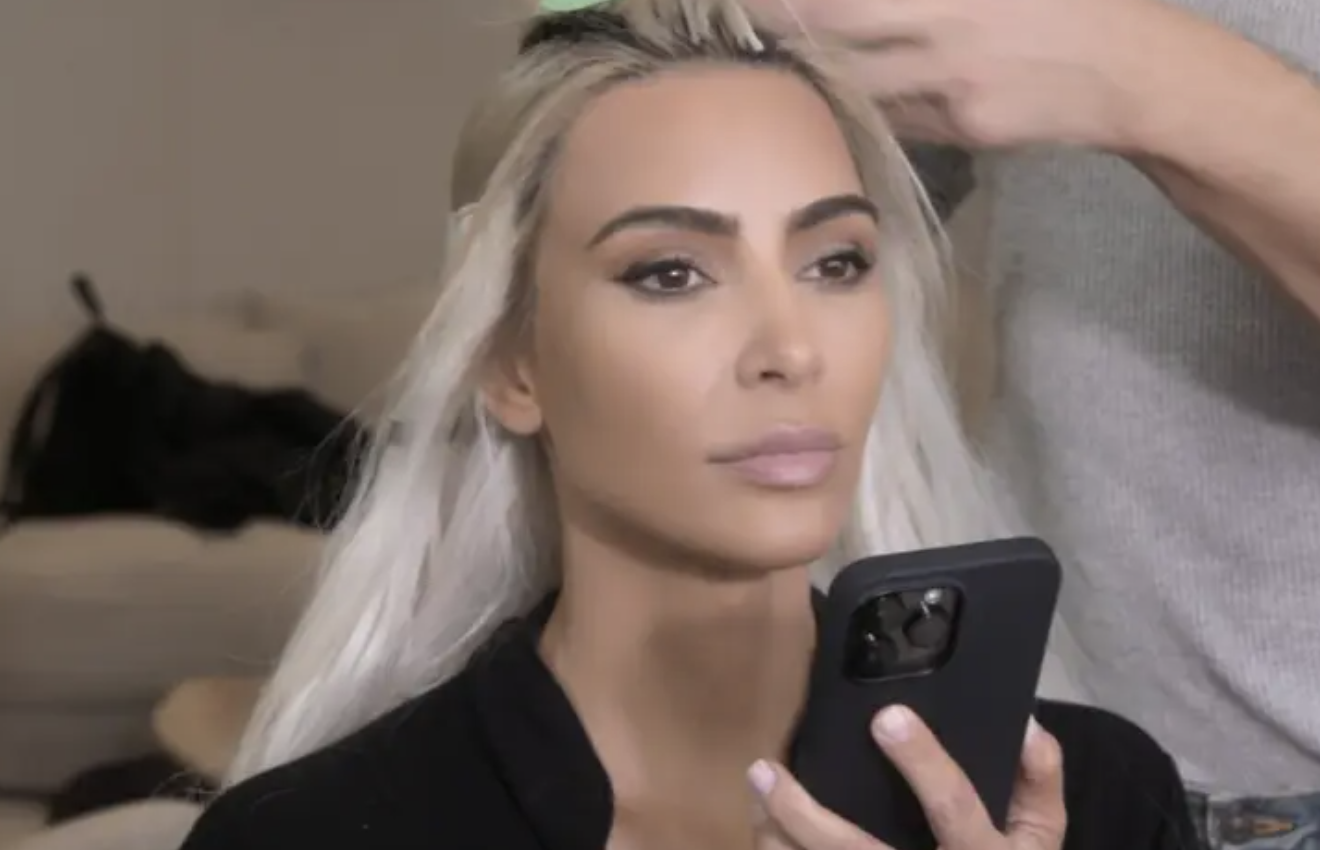 kim on the phone while getting glam done
