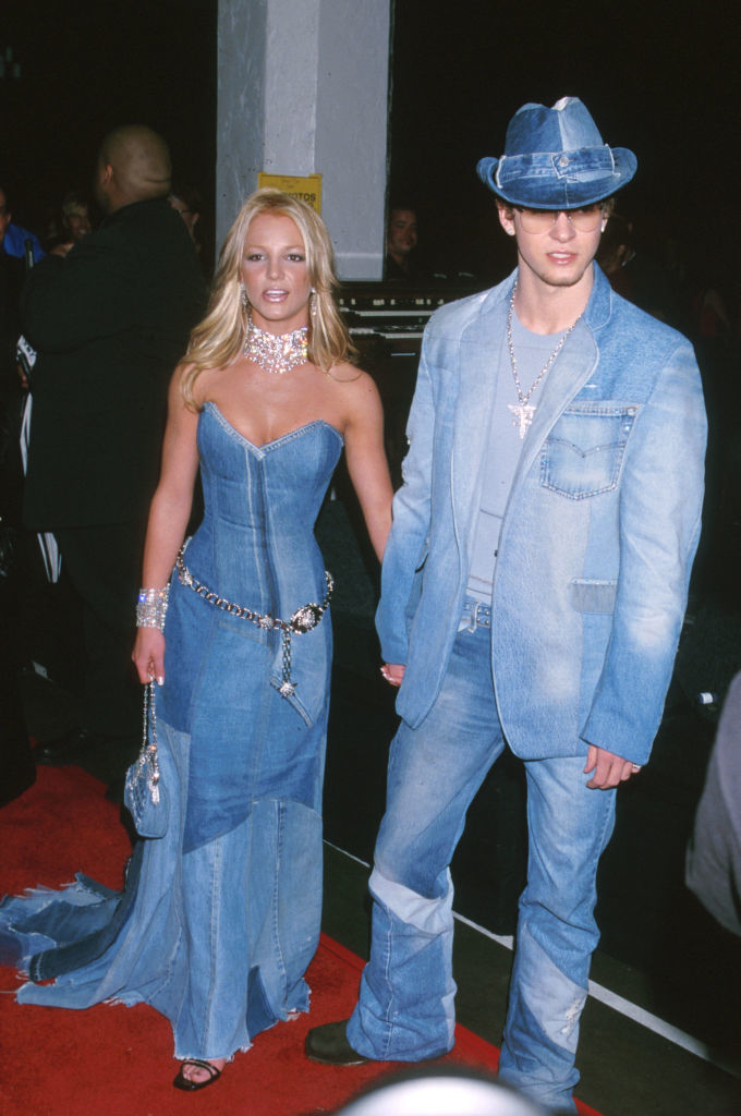 the couple holding hands wearing all denim on the red carpet