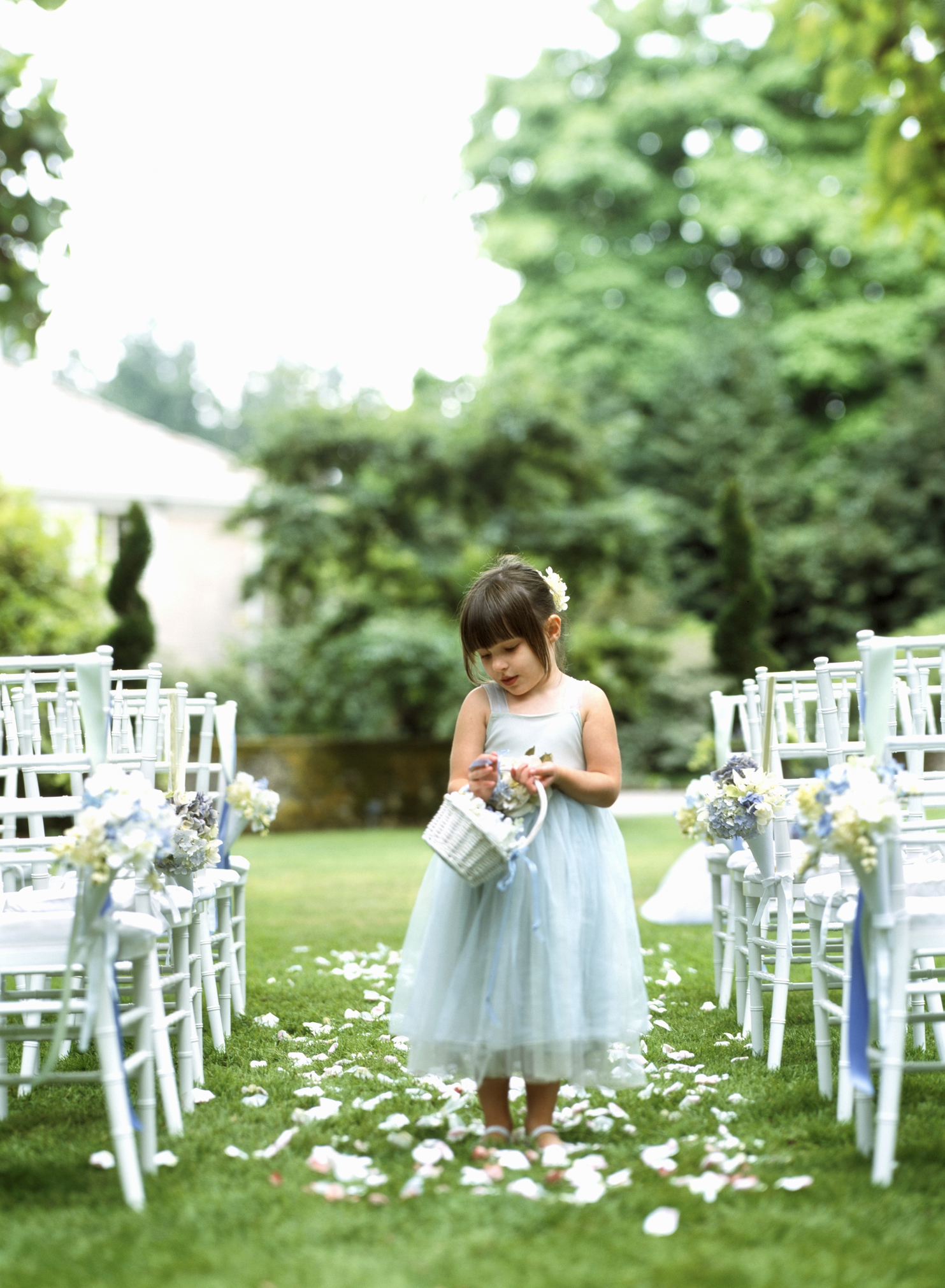 A little girl throwing flowers on the ground at a wedding