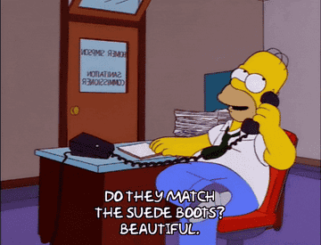 Homer Simpson sitting at a desk while talking on the phone and saying &quot;Do they match the suede boots? Beautiful.&quot;