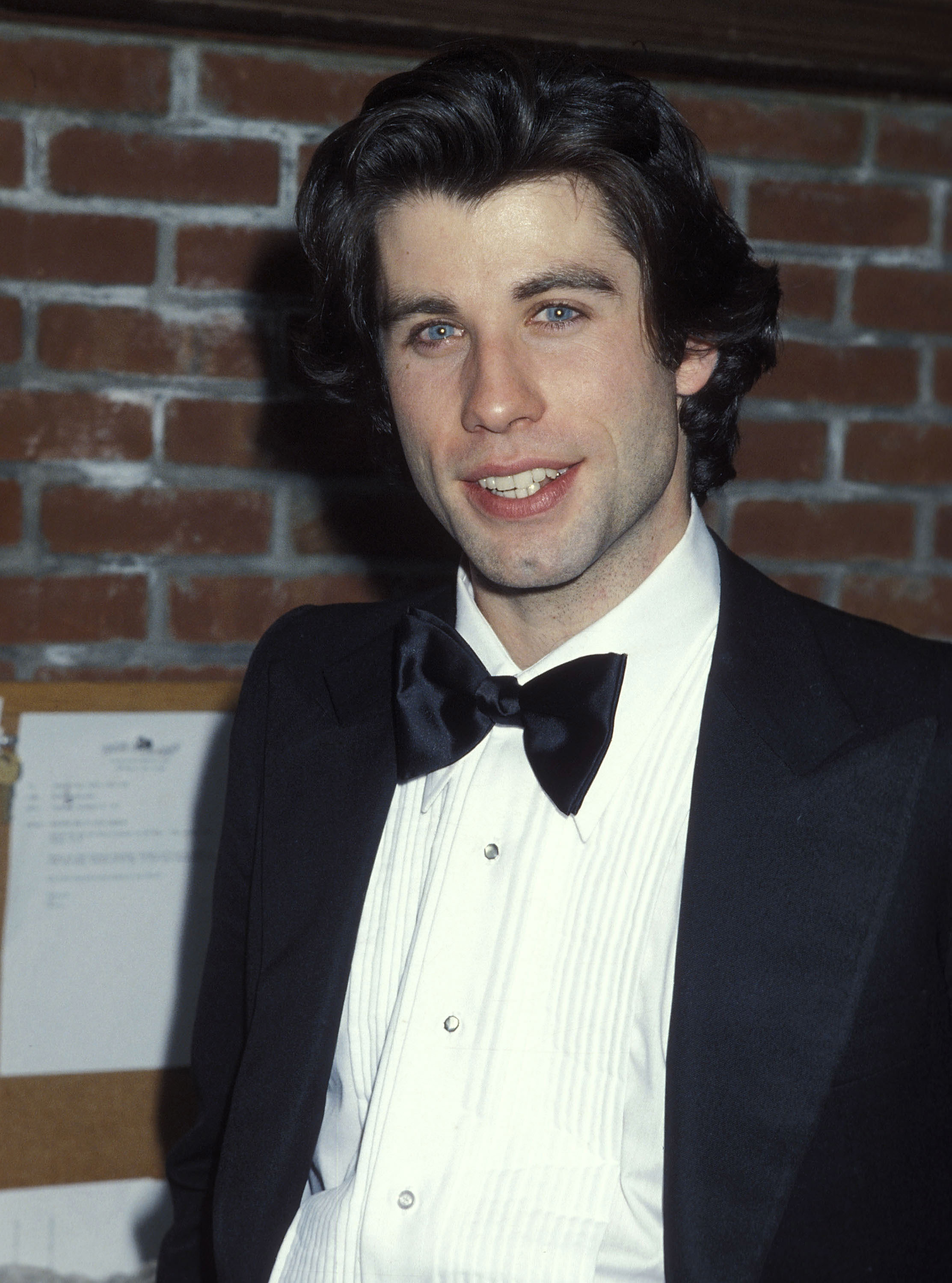 young travolta in a suit and long hair