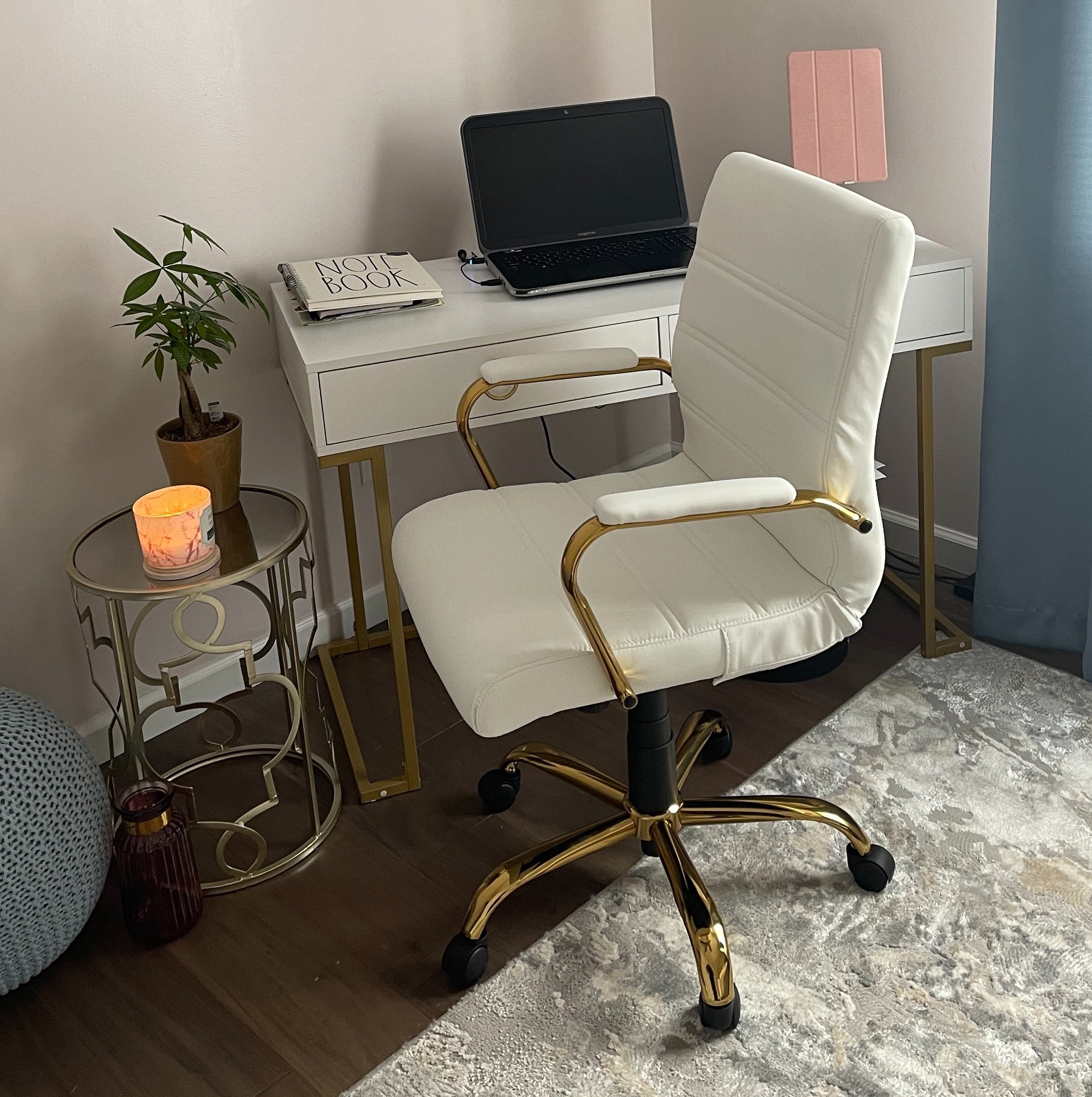 a reviewer photo of the white chair with a gold base and arm rests