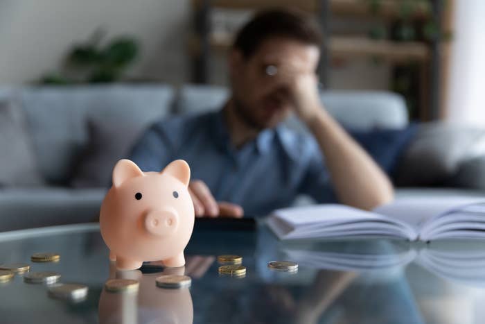 man stressed with empty piggy bank