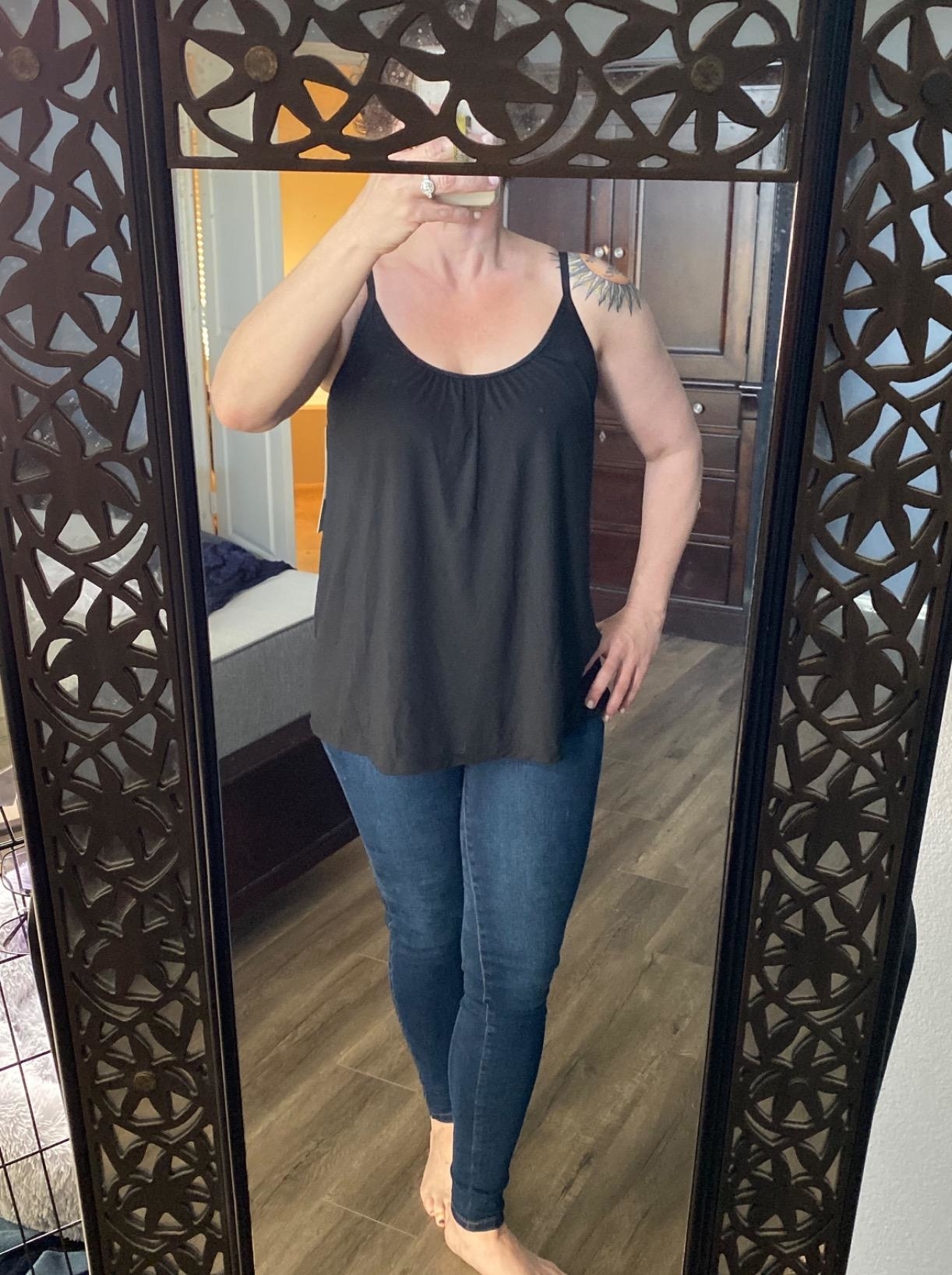 reviewer wearing the flowy tank in black with skinny jeans