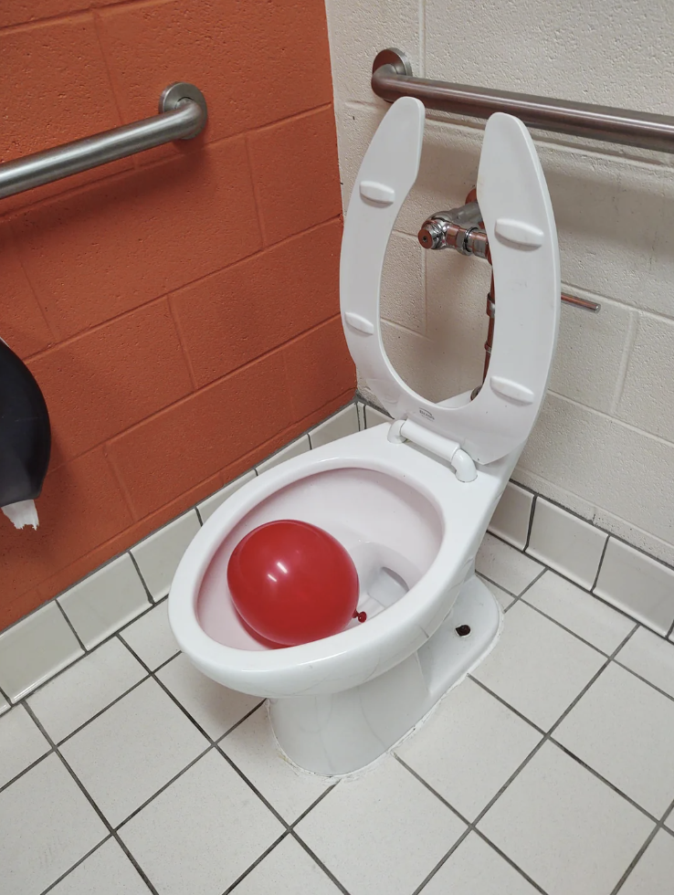 A red balloon in a toilet