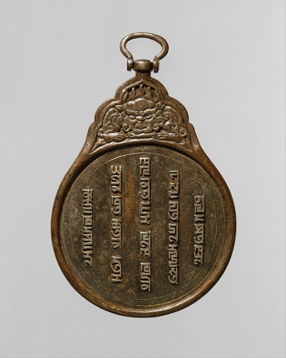 A spherical, metallic hanging badge with inscription