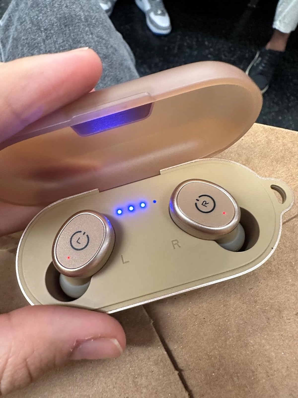 Reviewer holding the earbuds in their case